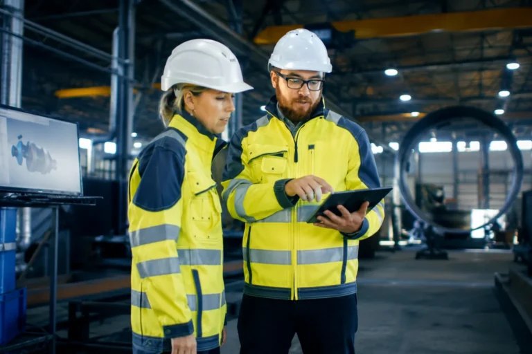 Trabajadores revisando medidas de seguridad laboral en una industria para ayudas de prevención de riesgos laborales 2026 en Andalucía
